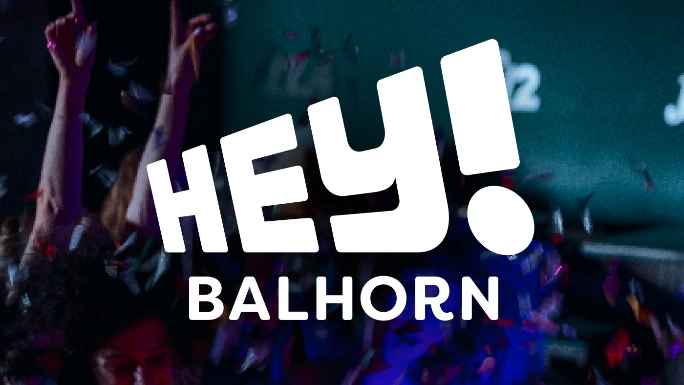 Young people celebrating at a party with confetti and the white lettering "HEY! BALHORN".