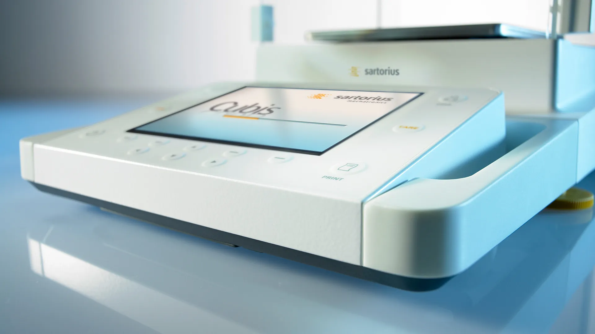 Ein Sartorius Cubis Laborgerät mit Touchscreen-Display und Tastenfeld auf einer reflektierenden Oberfläche.